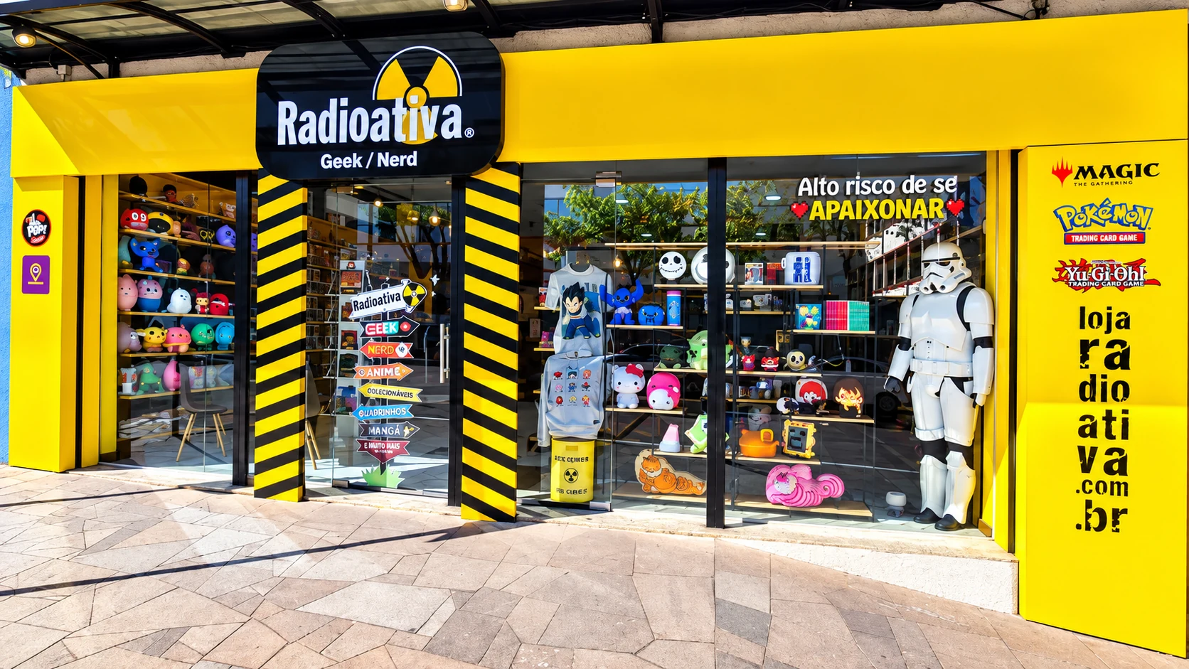 Fachada da loja Radioativa Geek Nerd, com entrada amarela e vitrine de produtos geek